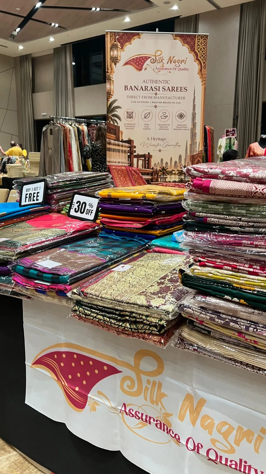 A Silk Nagri exhibition stall with racks and tables of Banarasi sarees
